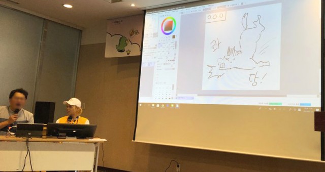 박지 작가가 토크쇼에서 드로잉 퀴즈를 진행하고 있다. 정답은 마이크. [사진=웹툰가이드]