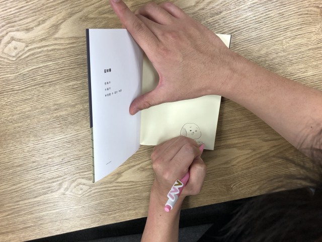 어른이 된다는 서글픈 일 사인을 하는 김보통 작가